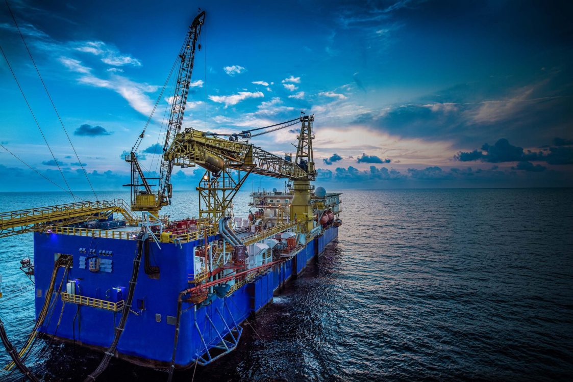 A large transporter ship is sat in front of a sunset