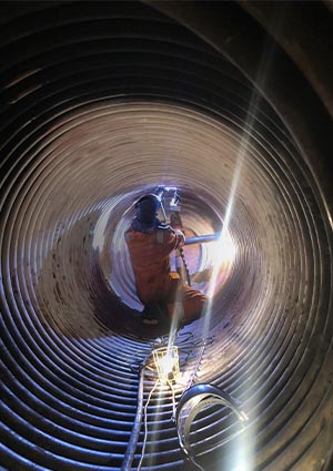 Welder working inside a large pipe