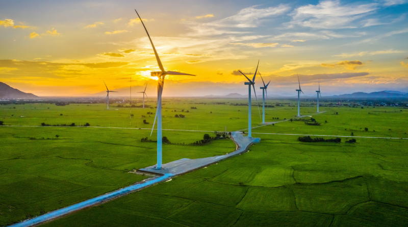 A vibrant solar farm with wind turbines under a bright sky, symbolizing advancements in renewable energy for 2025.