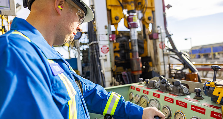 Oil worker checking dials on machinery