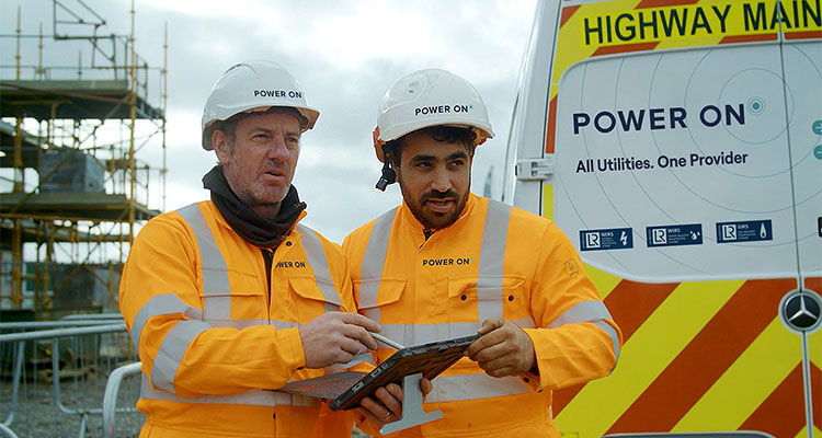 Two Power On workers checking a tablet