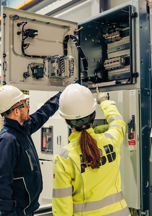  ABB service personnel inspecting a high-voltage electrical cabinet