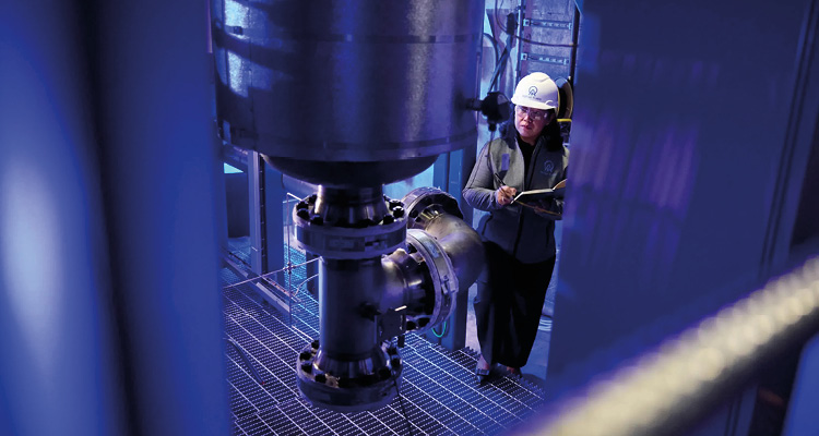 an engineer inspecting a industrial piping system at the Aether Fuels demo plant.