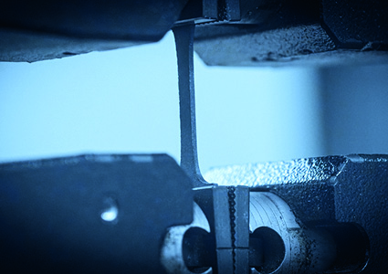 a tensile testing machine stretching a material sample until it breaks to measure its mechanical properties