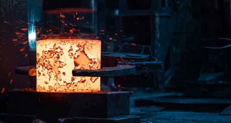 a glowing piece of superheated metal undergoing a heavy-duty industrial forging process
