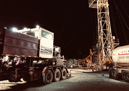 a Thru Tubing Solutions truck at a well intervention site at night