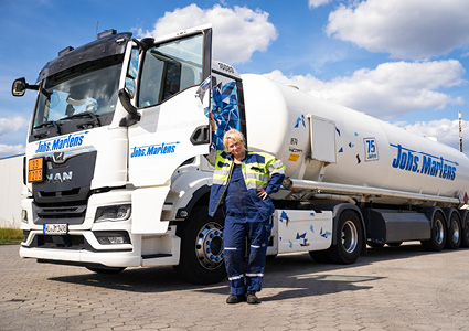 a driver posing in front of a modern hazardous-goods tanker truck